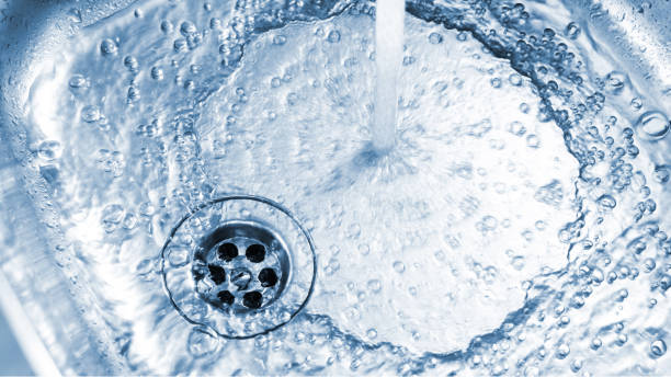 istock Water flowing into a stainless steel sink, creating bubbles and swirling down the drain, captured in a clean and refreshing moment 2173157164