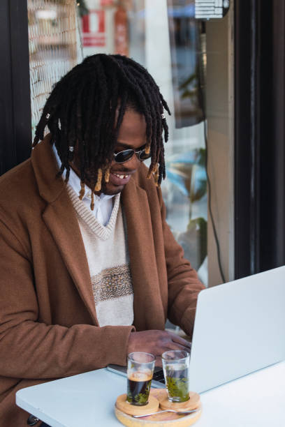 istock Happy black man browsing on laptop on restaurant terrace 2173166888