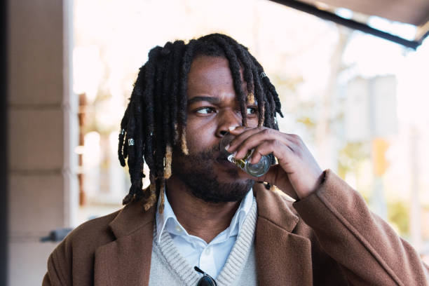 istock Black man drinking water in street cafe 2173166940
