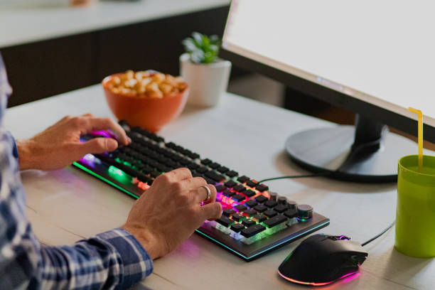istock Close-up of man's hands while playing computer games with rgb computer keyboard and mouse. 2173176515