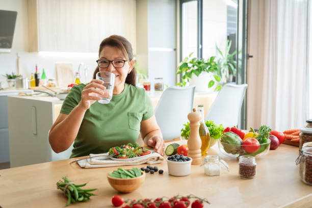 istock Woman drinking water while having fresh organic vegetables meal 2173177858
