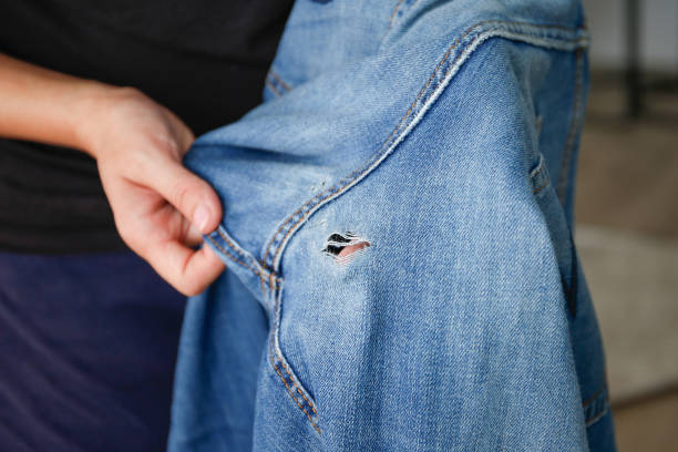 istock A woman holds jeans with a hole. 2173178298