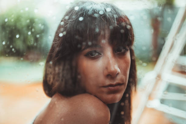 istock Woman looking at camera behind a wet glass 2173182250