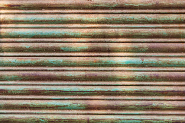 istock Green paint and rust on an old metal roller door. 2173191587
