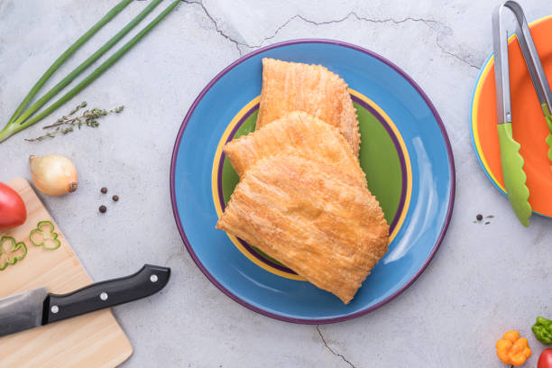 istock Three Jamaican beef patties on a large colourful plate 2173195090