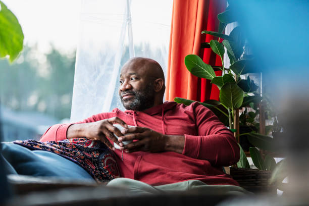 Mature multiracial man relaxing at home, drinking tea
