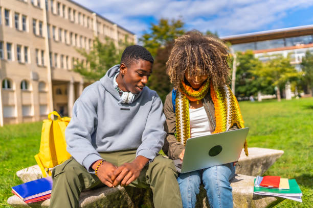 istock Multiracial students doing homework using laptop sitting outside the university 2173208818