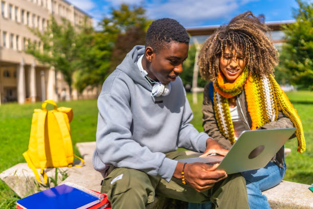 istock Students using laptop sitting at campus in a sunny day 2173208833