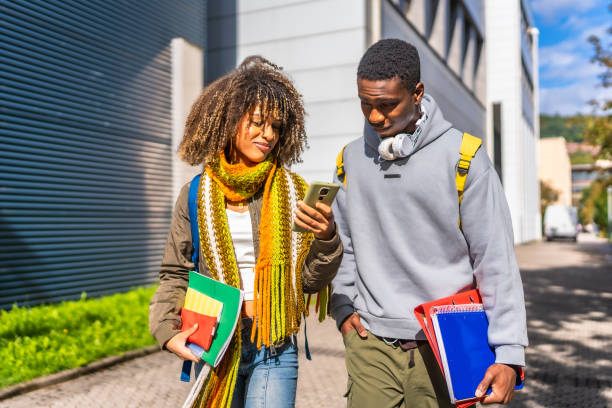 istock Students checking information with cellphone walking along the university campus 2173208840