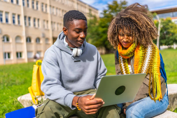 istock Students sitting with laptop on a bench at campus 2173208852