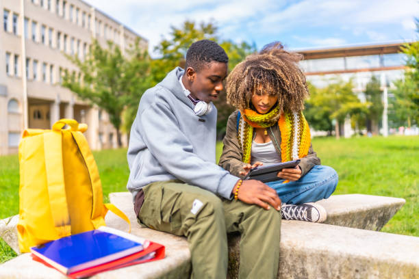 istock Friends using tablet to study together sitting outside the university 2173208861