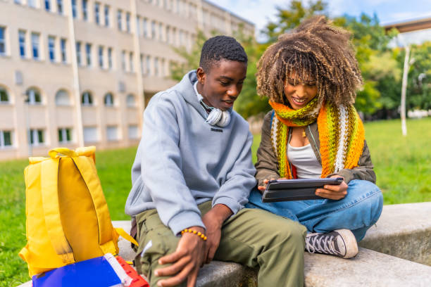 istock Friends sharing digital tablet outside university campus 2173208863