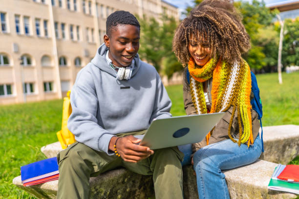 istock Multiethnic students studying together with a laptop sitting on campus 2173208877
