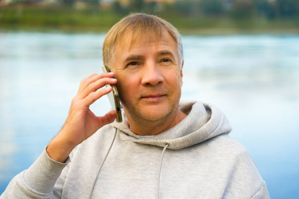 Man having phone call at the beach on a autumn day