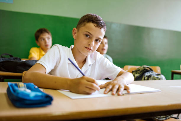 istock Students engaged in writing tasks in a classroom during a school day 2173227976