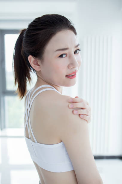 istock athletic woman holding her shoulder as if experiencing pain. 2173232596