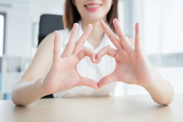 A woman making a heart shape with her hands