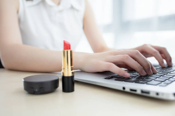 Pretty happy businesswoman doing make up in office