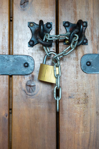 istock Rustic Wooden Door with Iron Structures Secured by Metal Chain and Padlock 2173242493