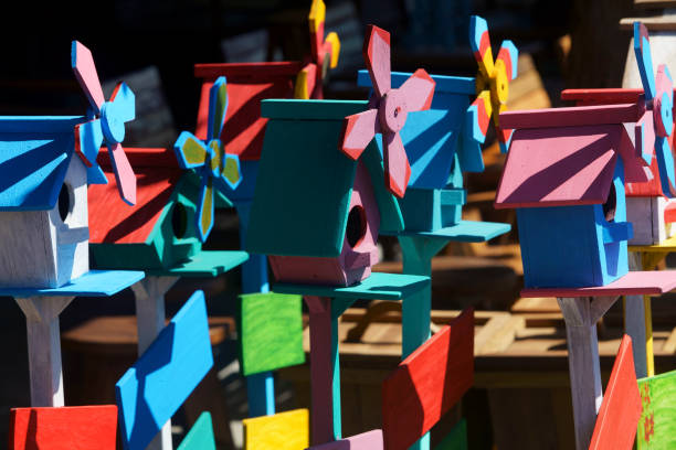 A collection of brightly painted birdhouses with whimsical designs, showcasing vibrant colors and playful elements, perfect for yard decorations.