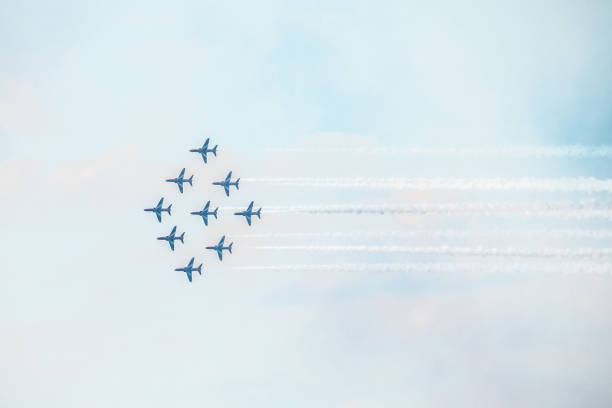 Toronto, Canada - September 1, 2024: A perfectly synchronized aerobatic jet team flies in a diamond formation, leaving thick smoke trails in the sky.