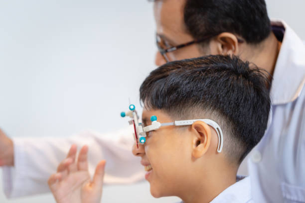 istock Boy doing eye test checking examination with optometrist in optical shop, Optometrist doing sight testing for child patient in clinic 2173261121