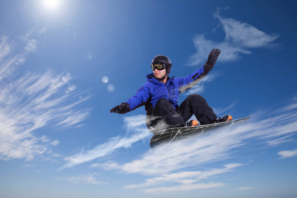 a snowboarder catapults into the air, executing a daring jump with unrivaled grace. Against the backdrop of pristine snow-covered peaks, the rider defies gravity, capturing a moment of thrilling aerial acrobatics