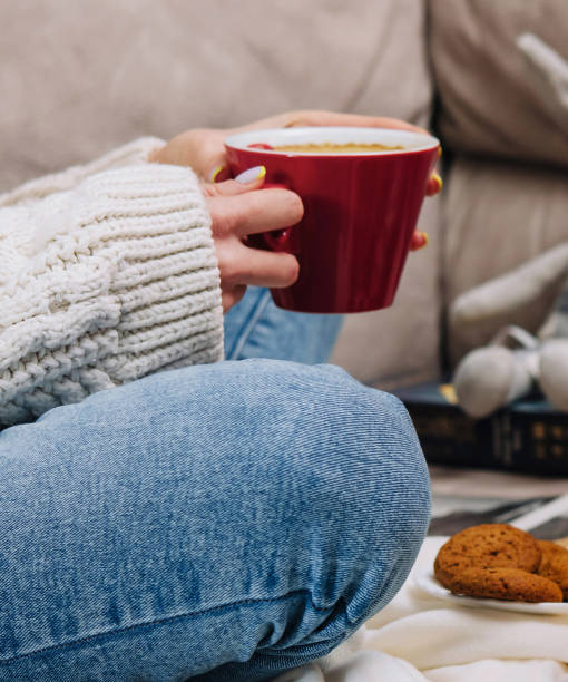 istock Woman relaxing on sofa with coffee and cookies 2173273304