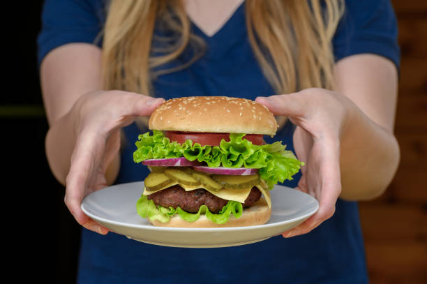 istock A waitress serving a beef cheeseburger with extras ordered at a grill bar, tasty fast food 2173276324
