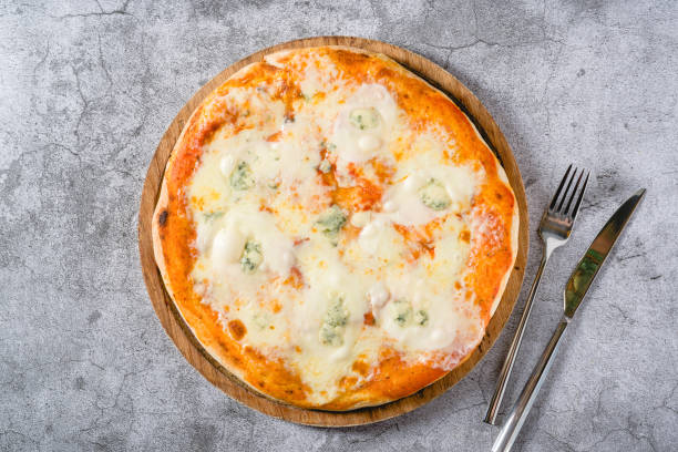 istock Four cheese neapolitan pizza on wooden cutting board on stone table 2173276898