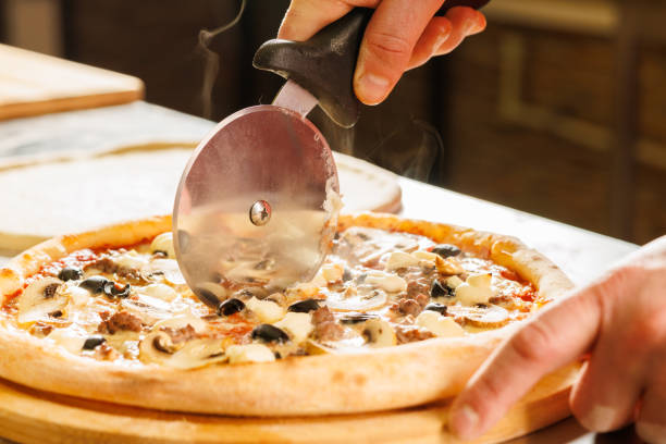 istock Cutting a freshly baked pizza with a pizza cutter 2173281469