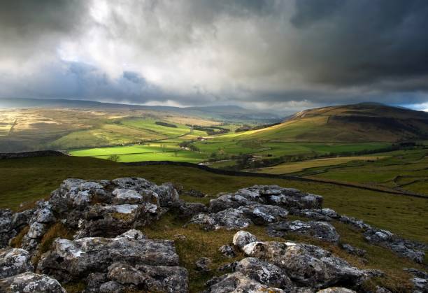 Barns at the side of a road in the rolling landscape of the southern area of the Yorkshire Dales National Park in England.
