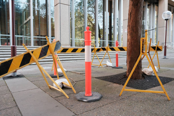 Metal barricades and a rubber bollard around a tree