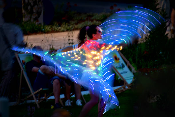 tulln, austria - june 27, 2024: female dancer at night with led lights on occasion of the opening of the new public park nibelungensquare at the river danube