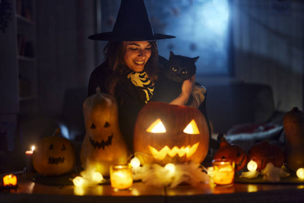 Happy witch with black cat on Halloween night.
