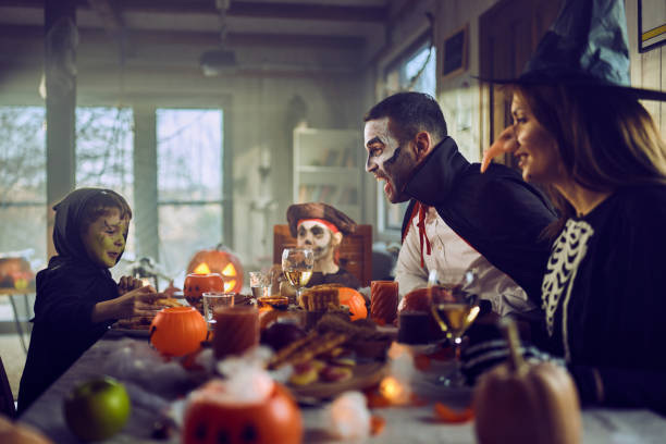 istock Happy family talking on Halloween at dining table. 2173301198