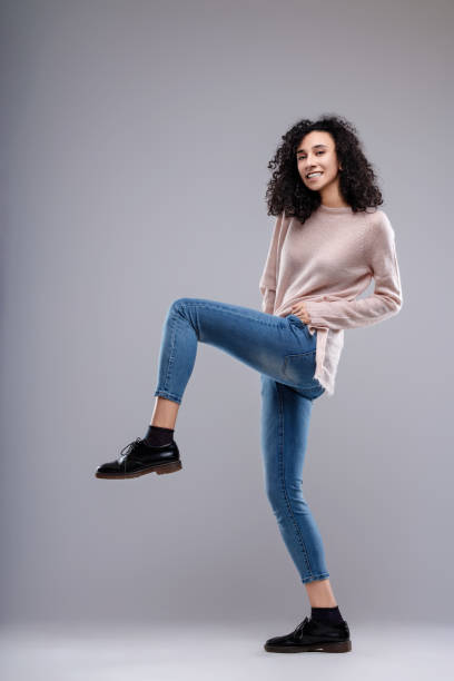 istock Young fashion model posing with kneed up leg in studio 2173301583