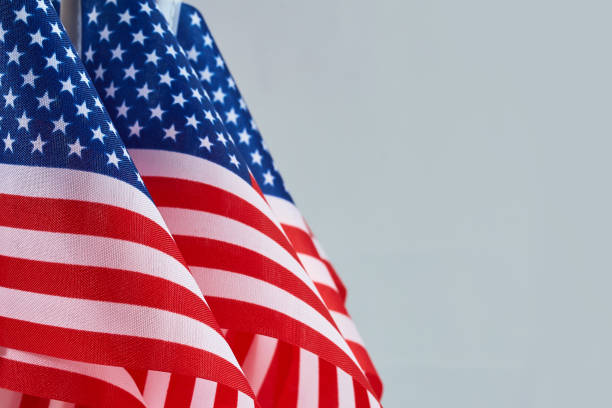 istock American Flags. Three American flags with stars and stripes on a light blue background. 2173302964