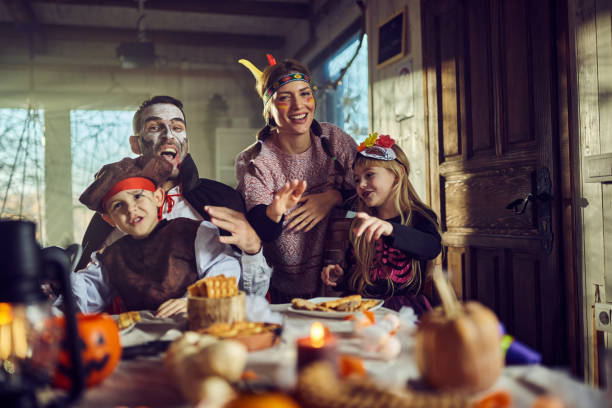 istock Happy family having fun on Halloween at dining table. 2173303048