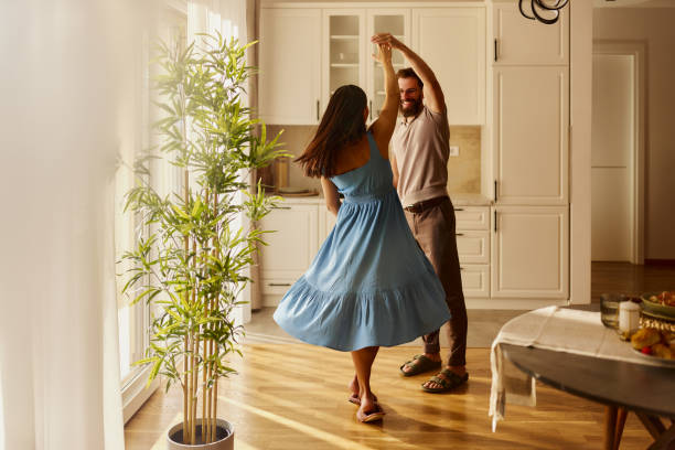 Carefree couple having fun while dancing at home.