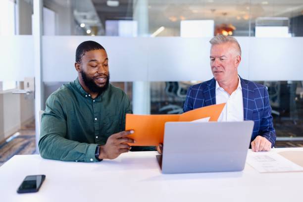 istock Two successful businessmen working on their laptop during a meeting 2173307115