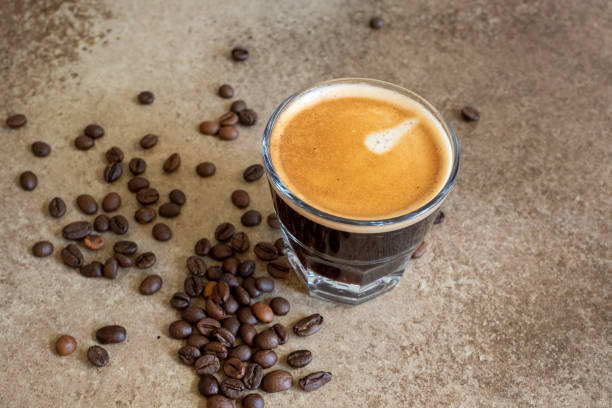 istock coffee beans on brown background and a cup of espresso coffee 2173311610
