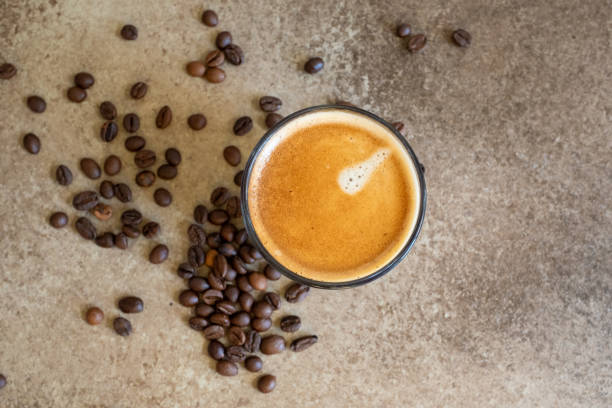 istock coffee beans on brown background and a cup of espresso coffee 2173311621