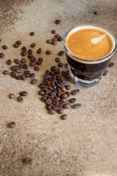 istock coffee beans on brown background and a cup of espresso coffee 2173311623