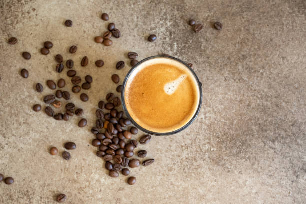 istock coffee beans on brown background and a cup of espresso coffee 2173311700