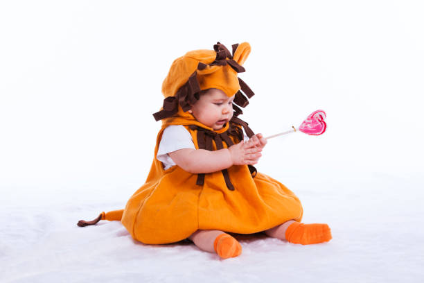 Handsome little baby boy with a funny lion mask (isolated on white)