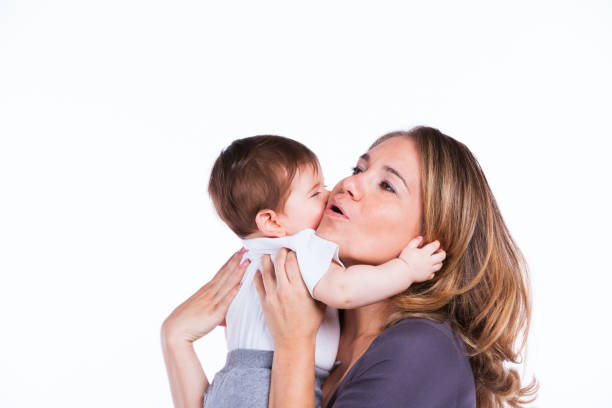 Happy mother playing with her baby son (isolated on white)