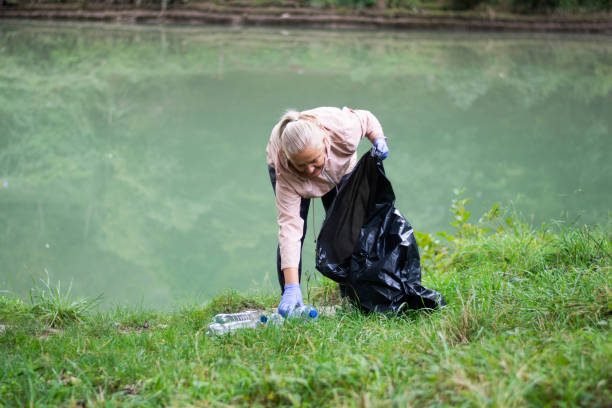 istock Volunteer collects trash on the river bank 2173313871
