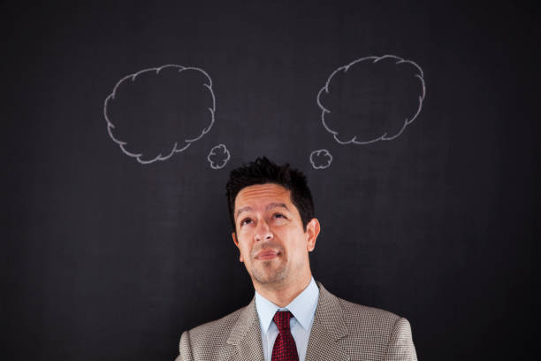 a man stands with apprehension, his demeanor reflecting uncertainty and doubt. The chalkboard, typically a canvas for clarity, now mirrors the complexities of his thoughts. In this introspective moment, he grapples with questions and concerns, creating an atmosphere of contemplation and introspection within the educational setting