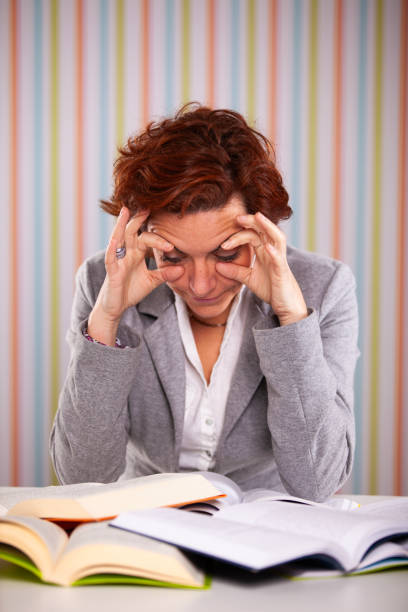 Businesswoman overloaded with work holding her eyes open